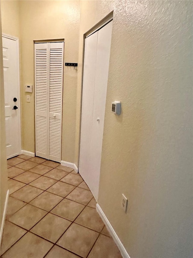 hall with light tile patterned floors