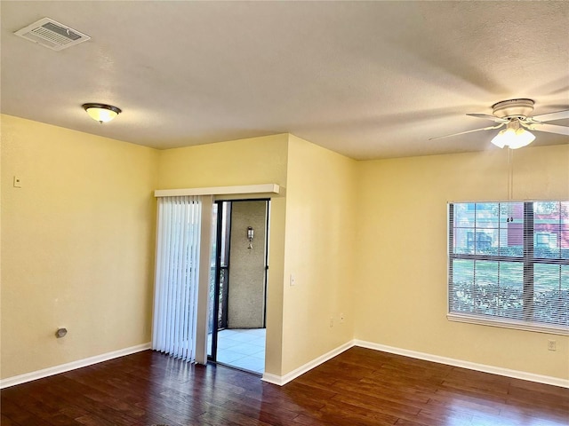 spare room featuring ceiling fan and dark wood-type flooring