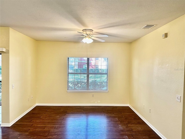 unfurnished room featuring dark hardwood / wood-style floors, ceiling fan, and a textured ceiling