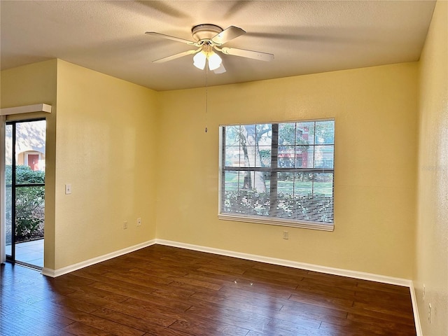 spare room featuring ceiling fan and dark wood-type flooring