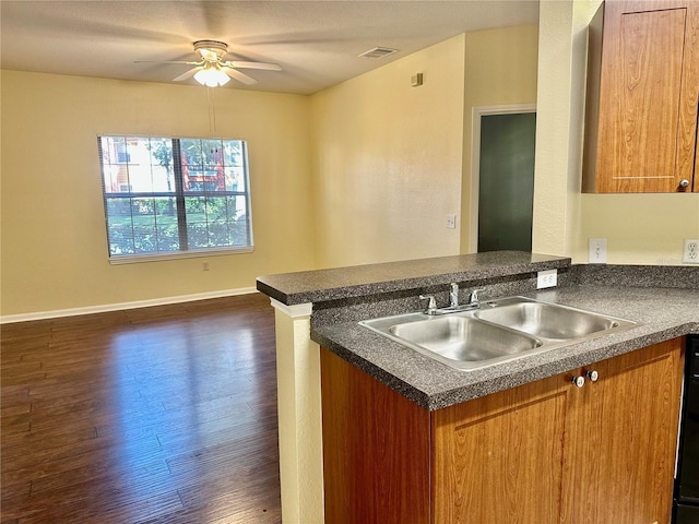 kitchen with kitchen peninsula, dark hardwood / wood-style floors, ceiling fan, and sink