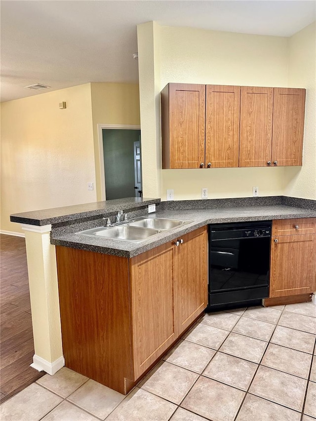 kitchen featuring sink, kitchen peninsula, black dishwasher, and light tile patterned floors