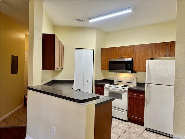 kitchen featuring kitchen peninsula, electric panel, light tile patterned flooring, and white appliances