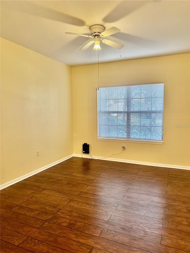 empty room featuring ceiling fan and dark wood-type flooring