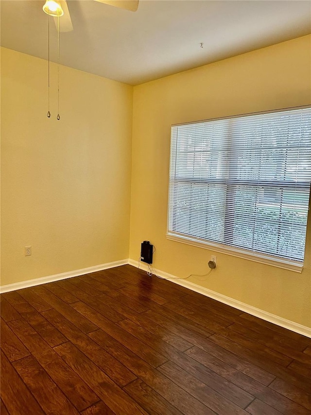 empty room with ceiling fan and dark hardwood / wood-style floors