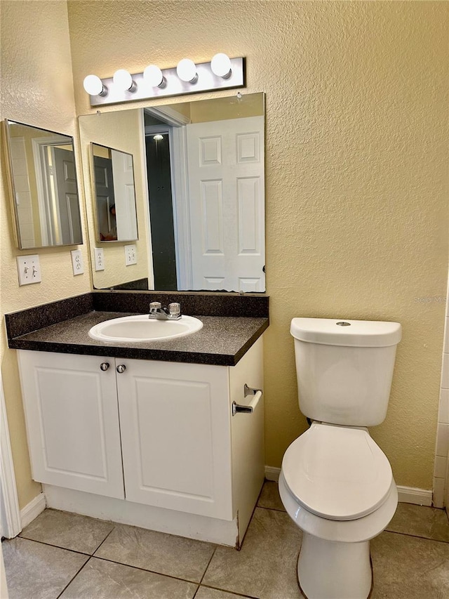 bathroom featuring tile patterned floors, vanity, and toilet