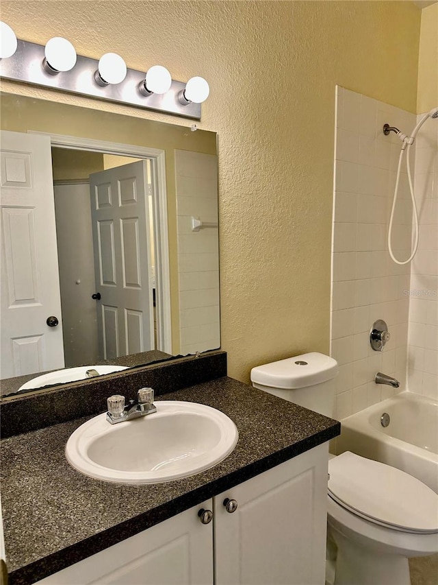 full bathroom featuring toilet, vanity, and tiled shower / bath