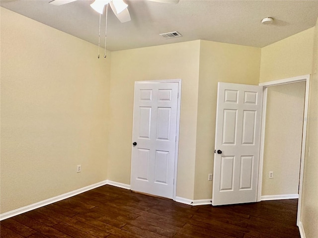 unfurnished bedroom featuring ceiling fan and dark wood-type flooring