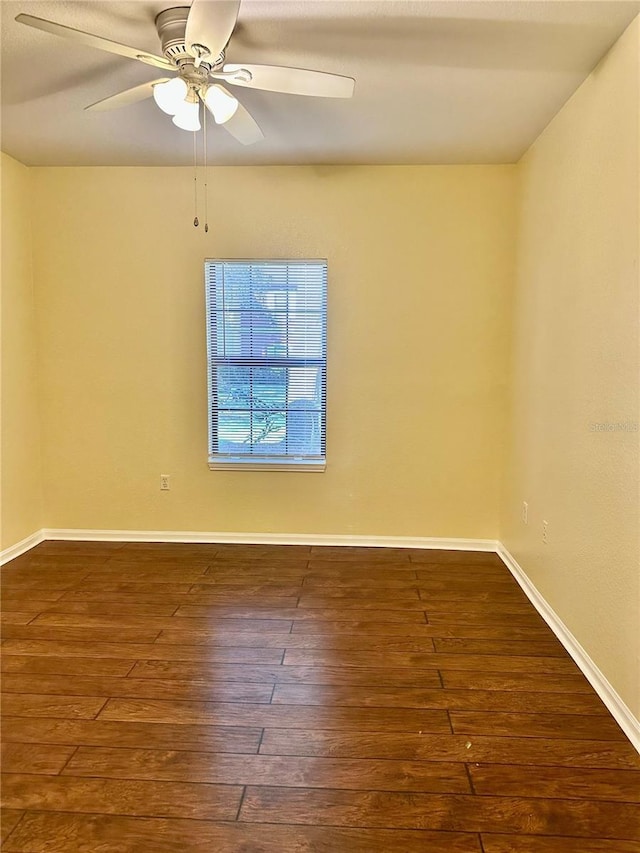 empty room with ceiling fan and dark hardwood / wood-style flooring