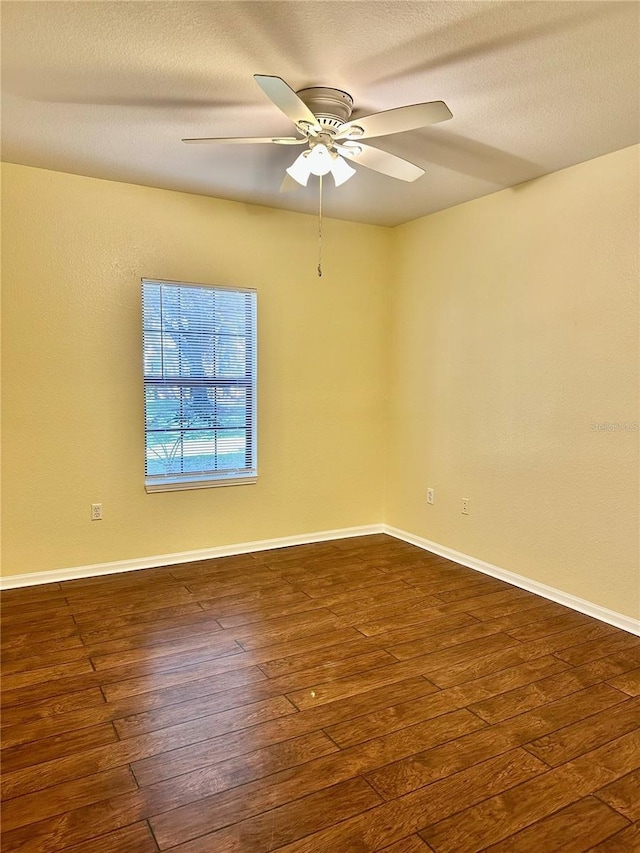 spare room with ceiling fan and dark wood-type flooring