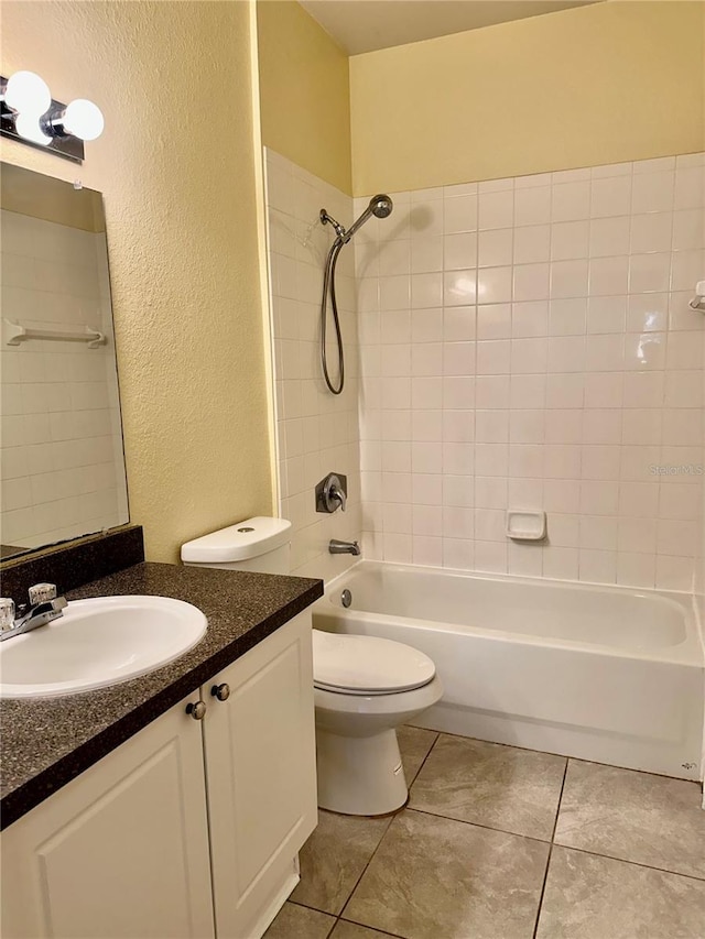 full bathroom featuring tile patterned floors, vanity, tiled shower / bath combo, and toilet