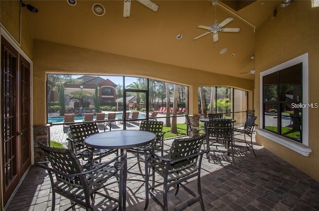 sunroom / solarium with ceiling fan and vaulted ceiling