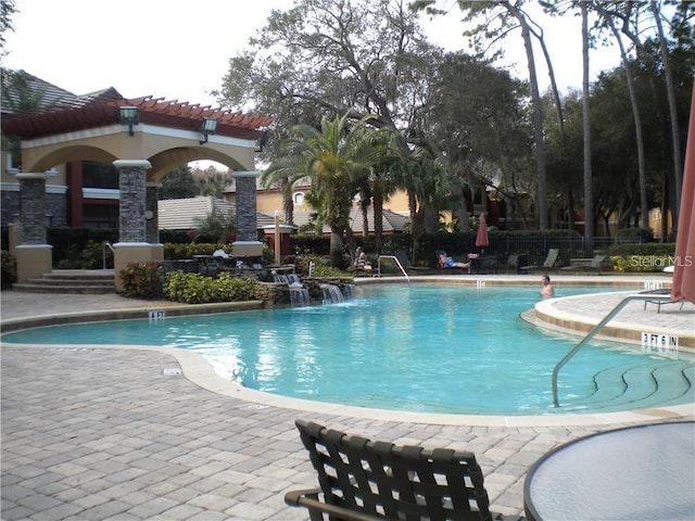 view of pool featuring pool water feature and a patio