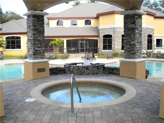 view of swimming pool featuring a patio area and a hot tub