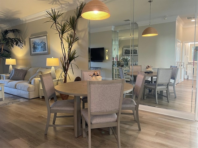 dining room with hardwood / wood-style floors and ornamental molding