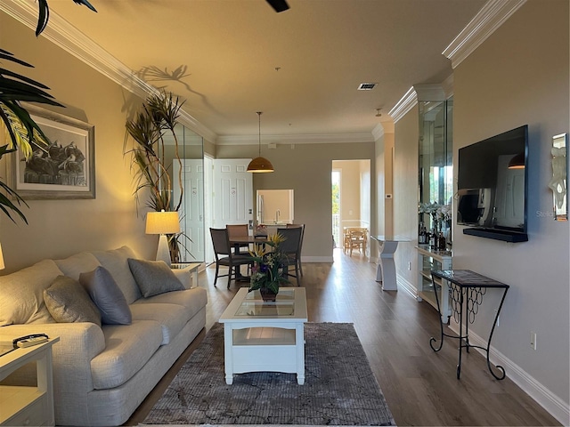 living room with dark wood-type flooring and crown molding