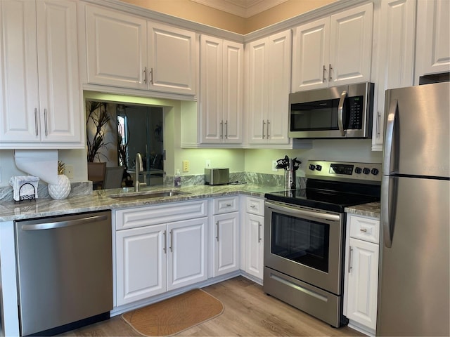 kitchen featuring white cabinets, sink, light stone countertops, and stainless steel appliances