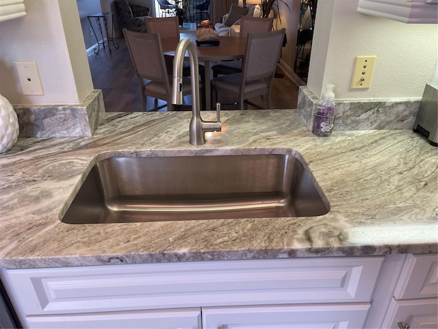 interior details with white cabinetry and sink