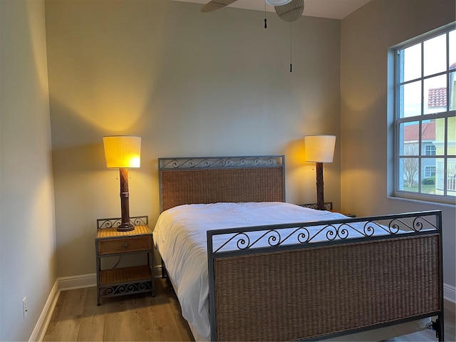 bedroom with wood-type flooring, multiple windows, and ceiling fan