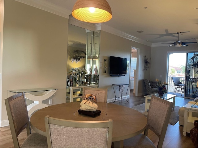 dining space with ceiling fan, crown molding, and hardwood / wood-style floors