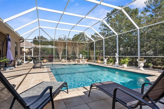 view of pool with glass enclosure and a patio