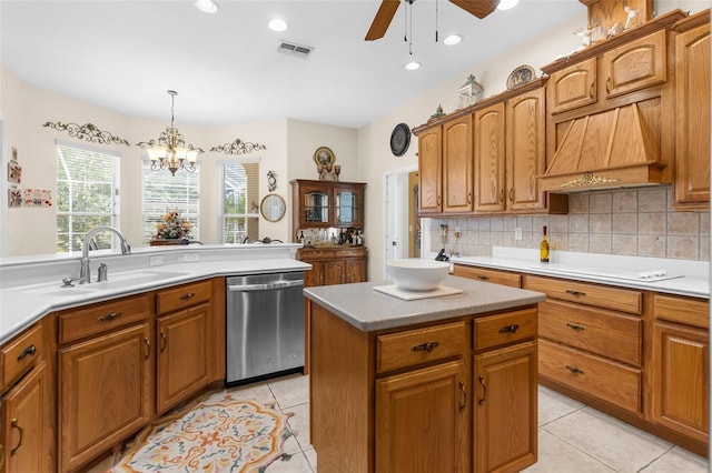 kitchen featuring backsplash, dishwasher, light tile patterned floors, and sink