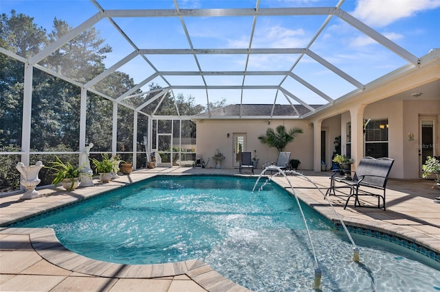 view of pool with glass enclosure, pool water feature, and a patio area