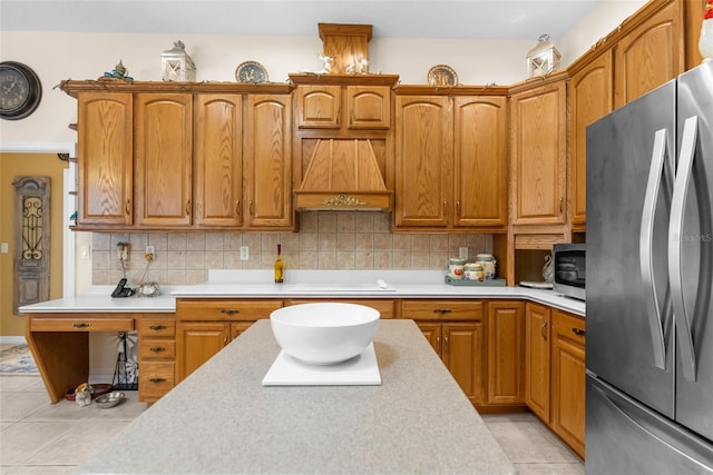 kitchen featuring decorative backsplash, light tile patterned floors, stainless steel appliances, and custom exhaust hood