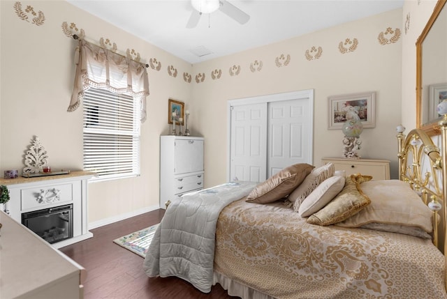 bedroom with dark hardwood / wood-style flooring, ceiling fan, and a closet