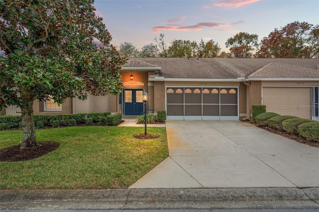 view of front of house featuring a garage and a lawn