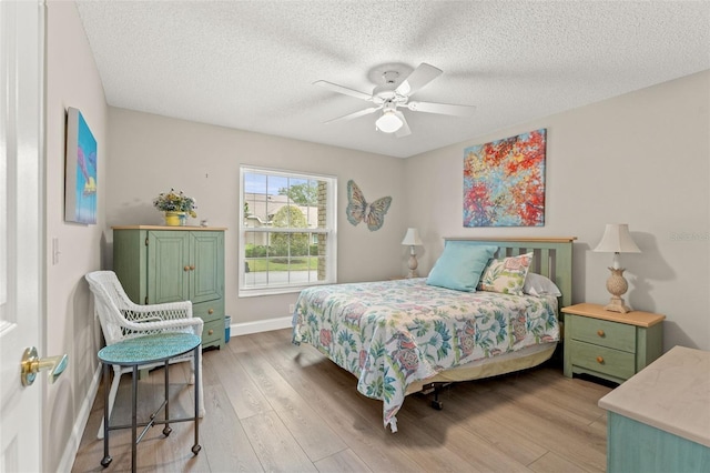 bedroom featuring hardwood / wood-style floors, a textured ceiling, and ceiling fan