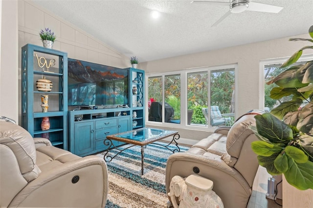 living room featuring ceiling fan, lofted ceiling, and a textured ceiling