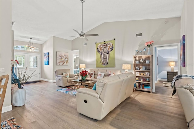 living room featuring ceiling fan, french doors, lofted ceiling, and light wood-type flooring