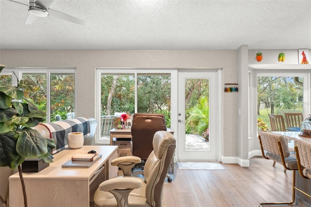 interior space with ceiling fan, light hardwood / wood-style floors, a textured ceiling, and a wealth of natural light