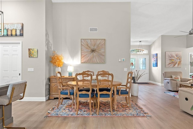 dining room with ceiling fan, french doors, and light hardwood / wood-style flooring