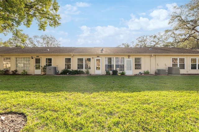 back of property with a lawn and cooling unit