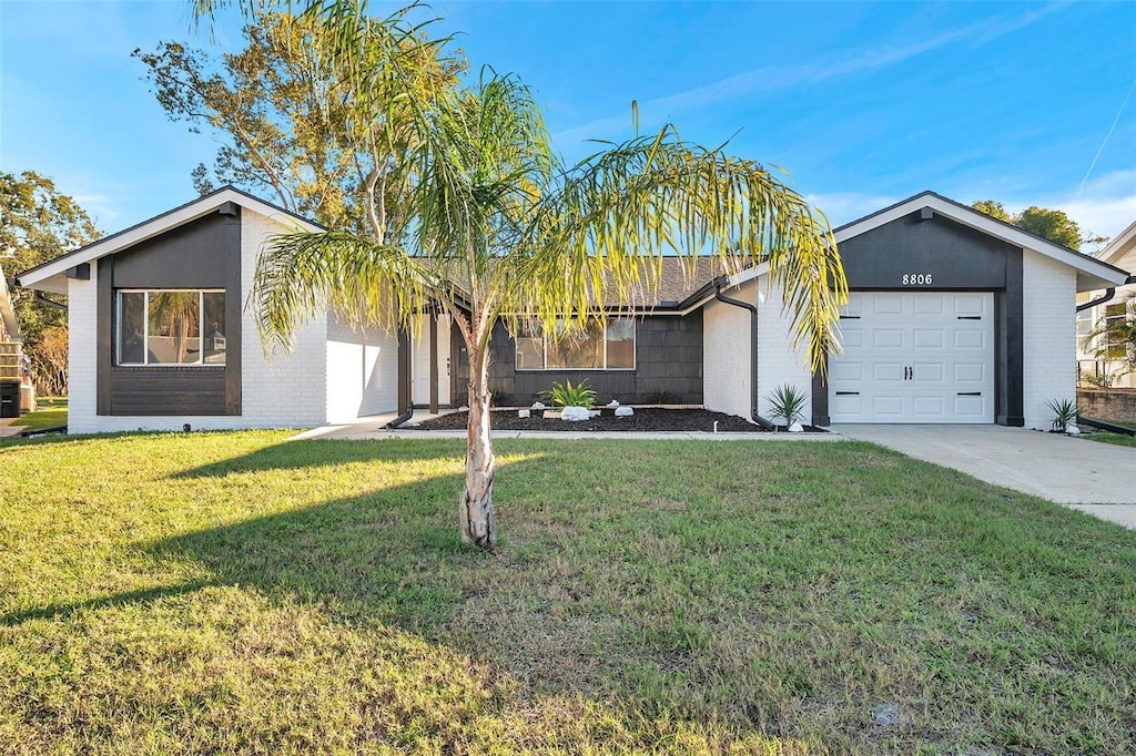 ranch-style house featuring a front yard and a garage