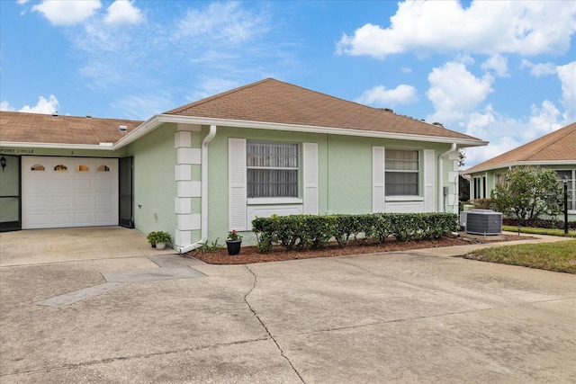 view of front of property featuring central air condition unit and a garage