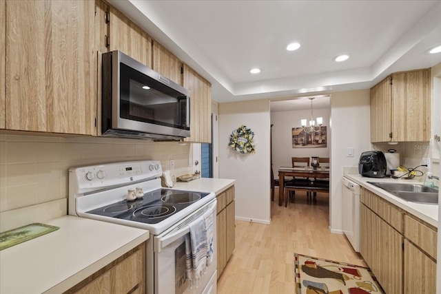 kitchen featuring white appliances, tasteful backsplash, light hardwood / wood-style flooring, pendant lighting, and a notable chandelier