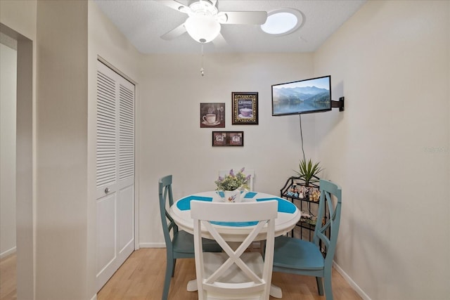 dining space with light hardwood / wood-style floors, ceiling fan, and a textured ceiling