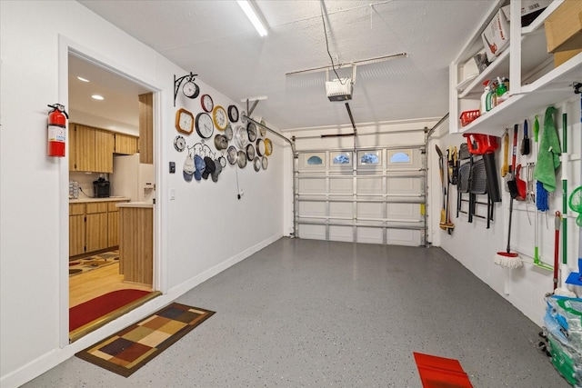 garage with a garage door opener and white fridge with ice dispenser