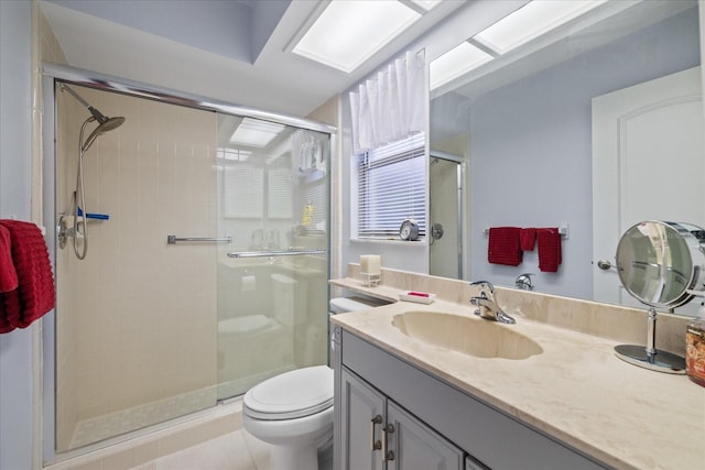 bathroom featuring toilet, vanity, tile patterned floors, and a shower with shower door