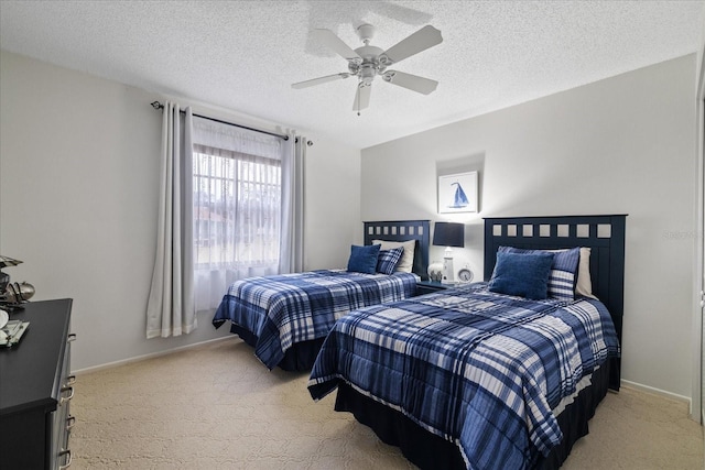 bedroom with a textured ceiling, ceiling fan, and light carpet