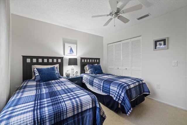 carpeted bedroom featuring ceiling fan, a closet, and a textured ceiling