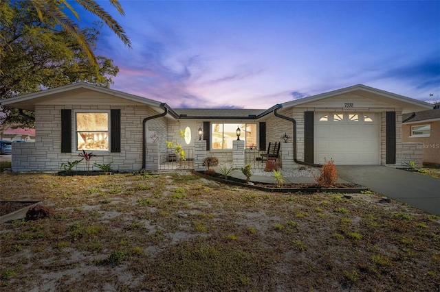 single story home featuring a porch and a garage