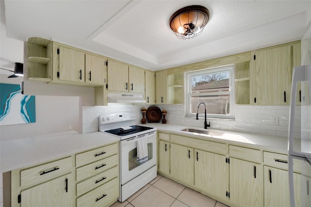 kitchen with sink, a textured ceiling, white appliances, light tile patterned floors, and a tray ceiling