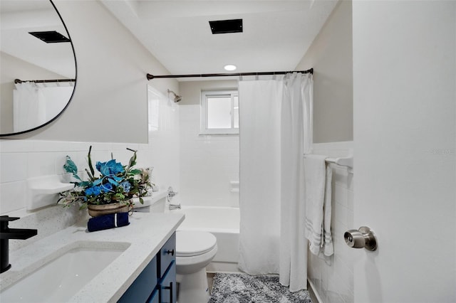 full bathroom featuring tile walls, shower / bath combination with curtain, vanity, and toilet