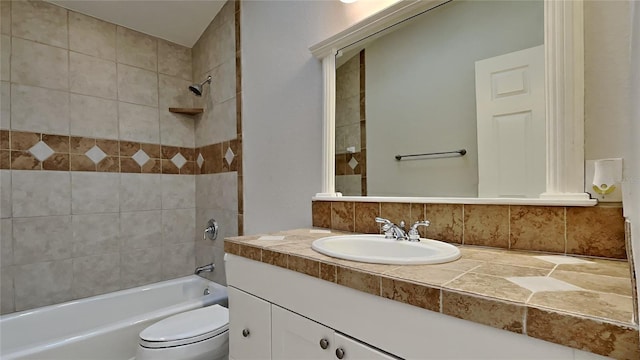 full bathroom with vanity, tasteful backsplash, toilet, and tiled shower / bath