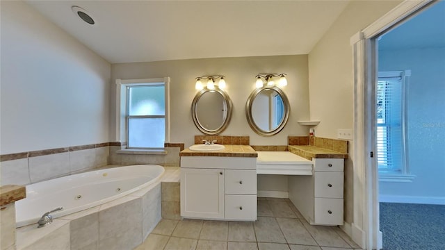 bathroom with tiled tub, tile patterned flooring, and vanity