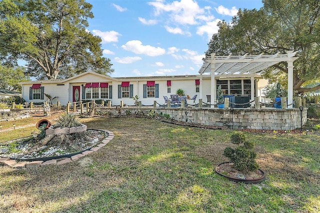 back of house featuring a pergola and a yard